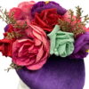 Purple velvet headpiece with an array of various coloured flowers.